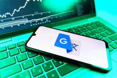 Prag, Çek Cumhuriyeti - 09 02 2025: Google Translate logosunu gösteren dizüstü bilgisayarlı telefon. Google Çevirisi metni ve konuşmayı diller arası çevirmek için bir platformdur..