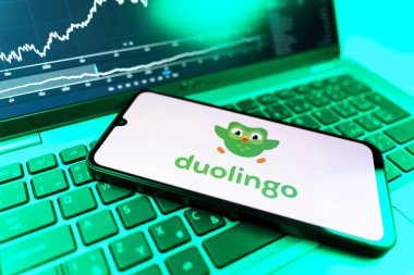 Prag, Çek Cumhuriyeti - 09 02 2025: Duolingo logosunu gösteren dizüstü bilgisayarlı telefon. Duolingo interaktif olarak dil öğrenmek için bir platformdur..