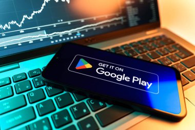 Prag, Çek Cumhuriyeti - 09 02 2025: Google Play logosunu gösteren dizüstü bilgisayarlı telefon. Google Play uygulamaları, oyunları ve dijital içeriği indirmek için bir platformdur.