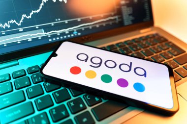 Prag, Çek Cumhuriyeti - 09 02 2025: Agoda logosunu gösteren dizüstü bilgisayarlı telefon. Agoda, otelleri ve seyahat yerlerini ayırtmak için bir platform..