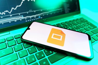 Prag, Çek Cumhuriyeti - 09 02 2025: Google Slides logosunu gösteren dizüstü bilgisayarlı telefon. Google Slides sunumlar ve slayt gösterileri oluşturmak için bir platformdur.