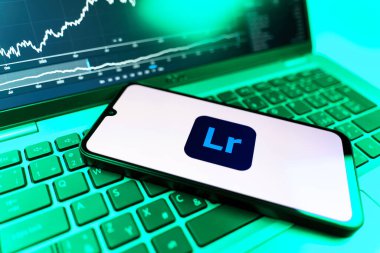 Prag, Çek Cumhuriyeti - 09 02 2025: Lightroom logosunu gösteren dizüstü bilgisayarlı telefon. Lightroom fotoğraf düzenleme ve yönetim için bir yazılımdır..