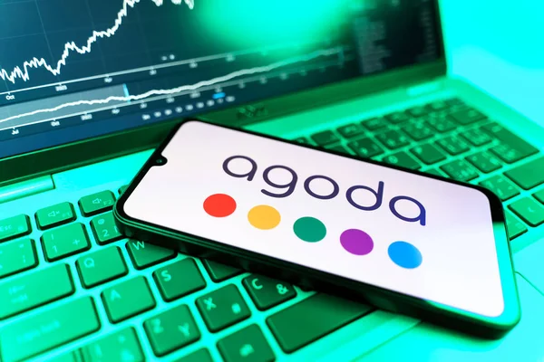 Prag, Çek Cumhuriyeti - 09 02 2025: Agoda logosunu gösteren dizüstü bilgisayarlı telefon. Agoda, otelleri ve seyahat yerlerini ayırtmak için bir platform..