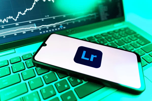 Prag, Çek Cumhuriyeti - 09 02 2025: Lightroom logosunu gösteren dizüstü bilgisayarlı telefon. Lightroom fotoğraf düzenleme ve yönetim için bir yazılımdır..