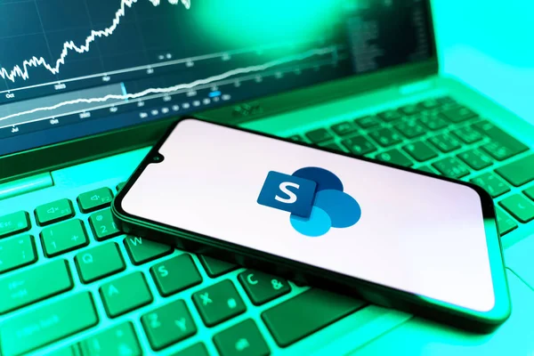Prag, Çek Cumhuriyeti - 09 02 2025: Microsoft Sharepoint logosunu gösteren dizüstü bilgisayarlı telefon. Microsoft Sharepoint işbirliği ve belge yönetimi için bir platformdur.