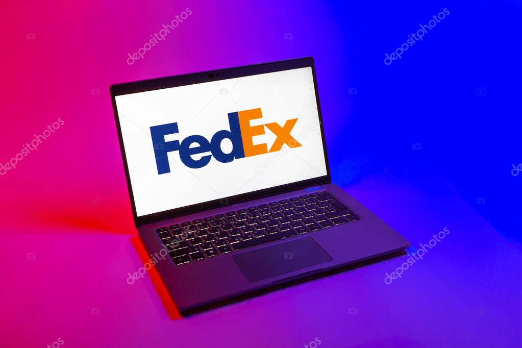 Prague, Czechia - 08 12 2025: A top-down view of a laptop on a uniform background displaying the FedEX logo. FedEX is a logistics company providing shipping and courier services.