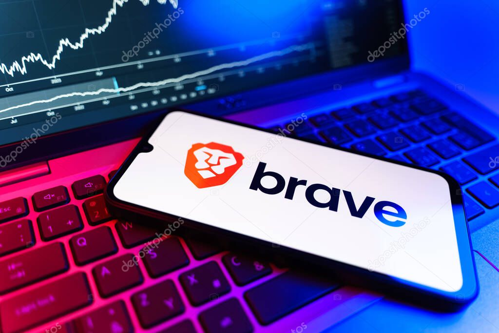 Prague, Czechia - 09 02 2025: Phone on laptop with stock chart showing Brave logo. Brave is a web browser focused on privacy and speed.