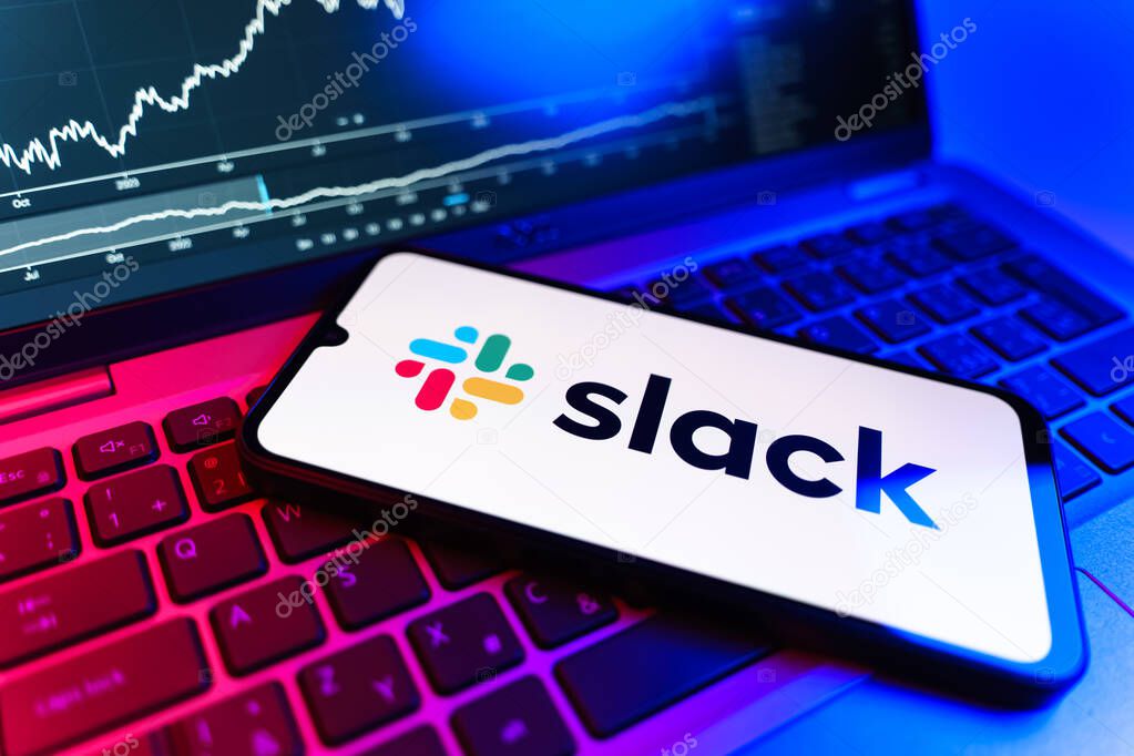 Prague, Czechia - 09 02 2025: Phone on laptop with stock chart showing Slack logo. Slack is a platform for team messaging and workplace communication.