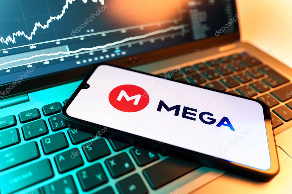 Prague, Czechia - 09 02 2025: Phone on laptop with stock chart showing Mega logo. Mega is a platform for cloud storage with encrypted file sharing.