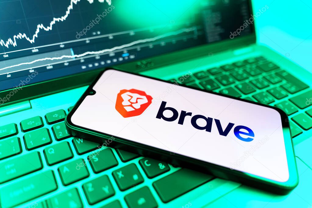 Prague, Czechia - 09 02 2025: Phone on laptop with stock chart showing Brave logo. Brave is a web browser focused on privacy and speed.