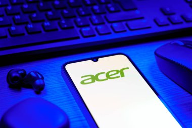 Prag, Çek Cumhuriyeti - 08 12 2025: Acer logosunu gösteren klavyesi ve cep telefonu olan bir masanın yan görüntüsü. Acer bilgisayar ve elektronik üreten bir teknoloji şirketidir..