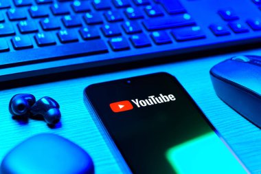 Prague, Czechia - 08 12 2025: A side view of a desk with a keyboard and a mobile phone displaying the Youtube logo. Youtube is a platform to watch and share videos worldwide.