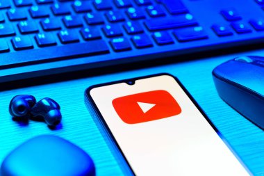 Prague, Czechia - 08 12 2025: A side view of a desk with a keyboard and a mobile phone displaying the Youtube logo. Youtube is a platform to watch and share videos worldwide.