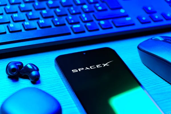 Prag, Çek Cumhuriyeti - 08 12 2025: SpaceX logosunu gösteren klavyesi ve cep telefonu olan bir masanın yan görüntüsü. SpaceX uzay keşfi ve roket fırlatmaları için özel bir şirkettir..