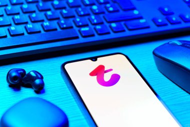 Prag, Çek Cumhuriyeti - 08 12 2025: Tango logosunu gösteren klavyesi ve cep telefonu olan bir masanın yan görüntüsü. Tango, görüntülü aramalar, mesajlar ve canlı yayınlar için sosyal bir uygulama..