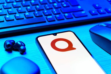 Prag, Çek Cumhuriyeti - 08 12 2025: Quora logosunu gösteren klavyesi ve cep telefonu olan bir masanın yan görüntüsü. Quora soru sormak ve bilgi paylaşmak için bir platformdur..