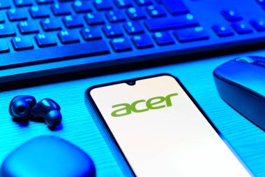Prag, Çek Cumhuriyeti - 08 12 2025: Acer logosunu gösteren klavyesi ve cep telefonu olan bir masanın yan görüntüsü. Acer bilgisayar ve elektronik üreten bir teknoloji şirketidir..