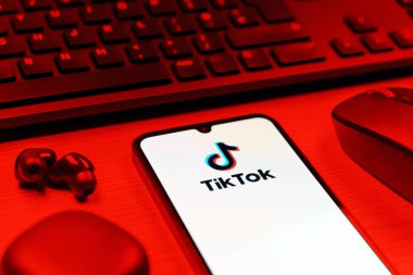 Prague, Czechia - 08 12 2025: A side view of a desk with a keyboard and a mobile phone displaying the TikTok logo. TikTok is a platform for short, creative, and viral videos.