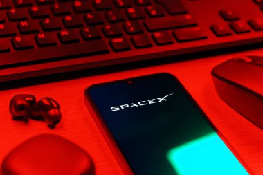 Prag, Çek Cumhuriyeti - 08 12 2025: SpaceX logosunu gösteren klavyesi ve cep telefonu olan bir masanın yan görüntüsü. SpaceX uzay keşfi ve roket fırlatmaları için özel bir şirkettir..
