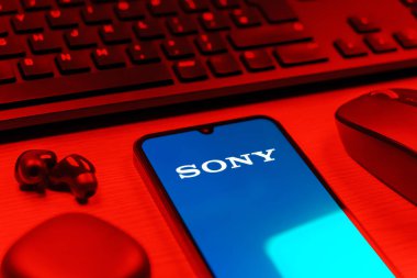 Prag, Çek Cumhuriyeti - 08 12 2025: Sony logosunu gösteren klavyesi ve cep telefonu olan bir masanın yan görüntüsü. Sony elektronik, oyun ve eğlence üreten bir teknoloji şirketidir..