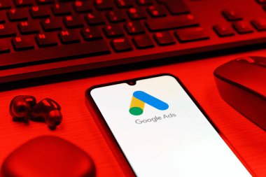 Prag, Çek Cumhuriyeti - 08 12 2025: Google Ads logosunu gösteren klavyesi ve cep telefonu olan bir masanın yan görüntüsü. Google Reklamları, çevrimiçi reklamlar yaratmak ve yönetmek için bir platformdur.