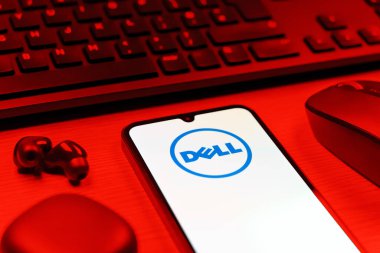 Prag, Çek Cumhuriyeti - 08 12 2025: Dell logosunu gösteren klavyesi ve cep telefonu olan bir masanın yan görüntüsü. Dell bilgisayar ve bilişim çözümleri üreten bir teknoloji şirketidir..