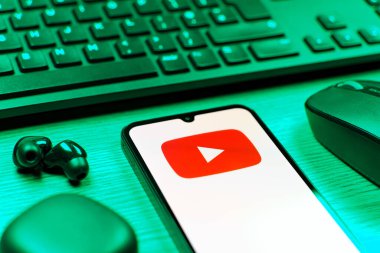 Prague, Czechia - 08 12 2025: A side view of a desk with a keyboard and a mobile phone displaying the Youtube logo. Youtube is a platform to watch and share videos worldwide.
