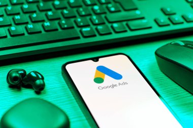 Prag, Çek Cumhuriyeti - 08 12 2025: Google Ads logosunu gösteren klavyesi ve cep telefonu olan bir masanın yan görüntüsü. Google Reklamları, çevrimiçi reklamlar yaratmak ve yönetmek için bir platformdur.