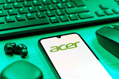 Prag, Çek Cumhuriyeti - 08 12 2025: Acer logosunu gösteren klavyesi ve cep telefonu olan bir masanın yan görüntüsü. Acer bilgisayar ve elektronik üreten bir teknoloji şirketidir..