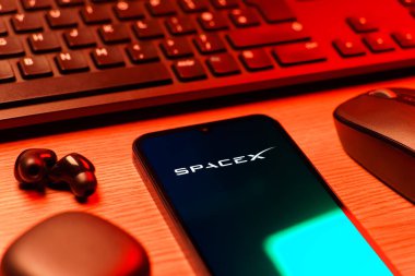 Prag, Çek Cumhuriyeti - 08 12 2025: SpaceX logosunu gösteren klavyesi ve cep telefonu olan bir masanın yan görüntüsü. SpaceX uzay keşfi ve roket fırlatmaları için özel bir şirkettir..