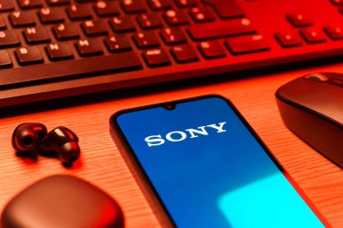 Prag, Çek Cumhuriyeti - 08 12 2025: Sony logosunu gösteren klavyesi ve cep telefonu olan bir masanın yan görüntüsü. Sony elektronik, oyun ve eğlence üreten bir teknoloji şirketidir..