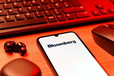 Prag, Çek Cumhuriyeti - 08 12 2025: Bloomberg logosunu gösteren klavyesi ve cep telefonu olan bir masanın yan görüntüsü. Bloomberg finansal haberler, veriler ve analizler sağlayan bir şirkettir..