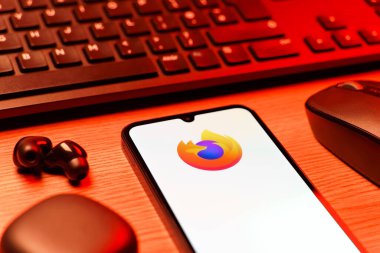 Prag, Çek Cumhuriyeti - 08 12 2025: Firefox logosunu gösteren klavyesi ve cep telefonu olan bir masanın yan görüntüsü. Firefox hızlı ve güvenli internet taraması için bir web tarayıcısıdır.
