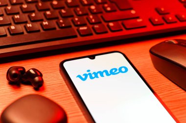 Prag, Çek Cumhuriyeti - 08 12 2025: Vimeo logosunu gösteren klavyesi ve cep telefonu olan bir masanın yan görüntüsü. Vimeo, yüksek kaliteli video sunucu ve paylaşımı için bir platformdur.