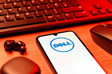 Prag, Çek Cumhuriyeti - 08 12 2025: Dell logosunu gösteren klavyesi ve cep telefonu olan bir masanın yan görüntüsü. Dell bilgisayar ve bilişim çözümleri üreten bir teknoloji şirketidir..