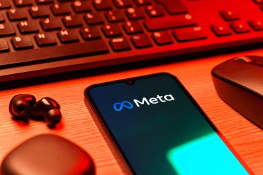 Prague, Czechia - 08 12 2025: A side view of a desk with a keyboard and a mobile phone displaying the Meta logo. Meta is a company offering social platforms like Facebook and Instagram.