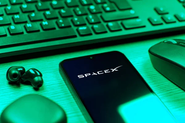 Prag, Çek Cumhuriyeti - 08 12 2025: SpaceX logosunu gösteren klavyesi ve cep telefonu olan bir masanın yan görüntüsü. SpaceX uzay keşfi ve roket fırlatmaları için özel bir şirkettir..