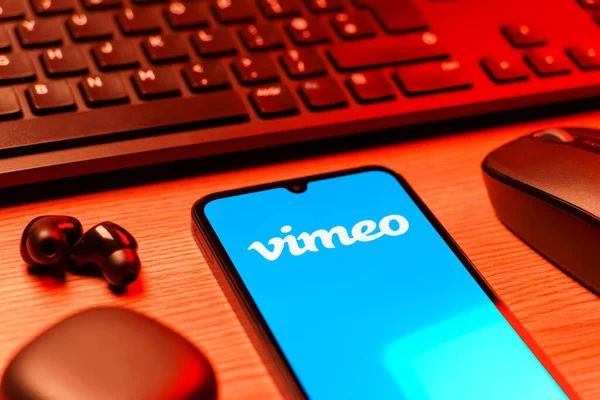 Prag, Çek Cumhuriyeti - 08 12 2025: Vimeo logosunu gösteren klavyesi ve cep telefonu olan bir masanın yan görüntüsü. Vimeo, yüksek kaliteli video sunucu ve paylaşımı için bir platformdur.