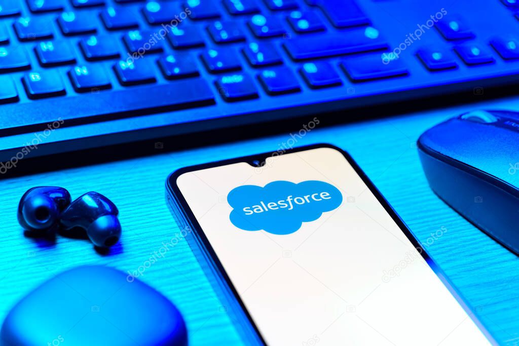 Prague, Czechia - 08 12 2025: A side view of a desk with a keyboard and a mobile phone displaying the Salesforce logo. Salesforce is a platform for customer relationship management and cloud services.