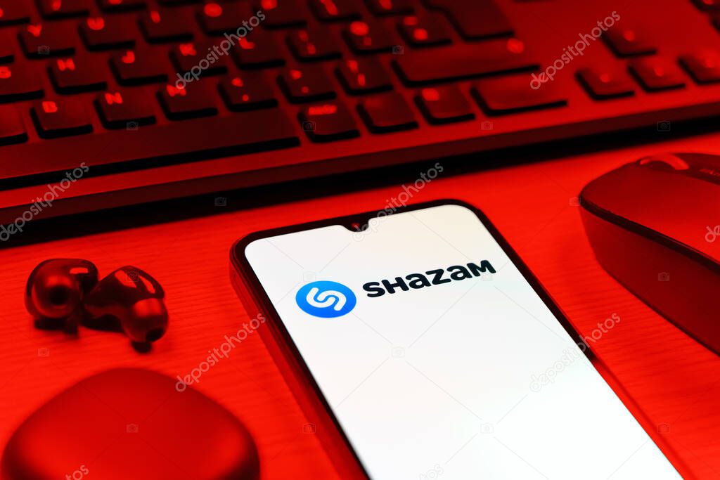 Prague, Czechia - 08 12 2025: A side view of a desk with a keyboard and a mobile phone displaying the Shazam logo. Shazam is an app for identifying songs and music tracks.