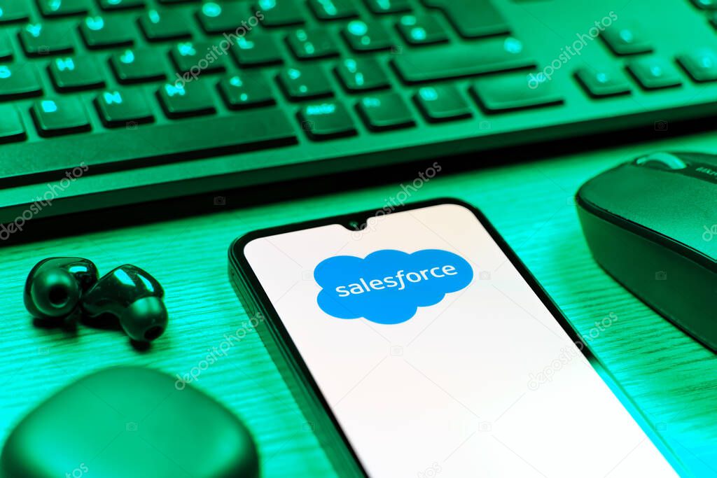 Prague, Czechia - 08 12 2025: A side view of a desk with a keyboard and a mobile phone displaying the Salesforce logo. Salesforce is a platform for customer relationship management and cloud services.