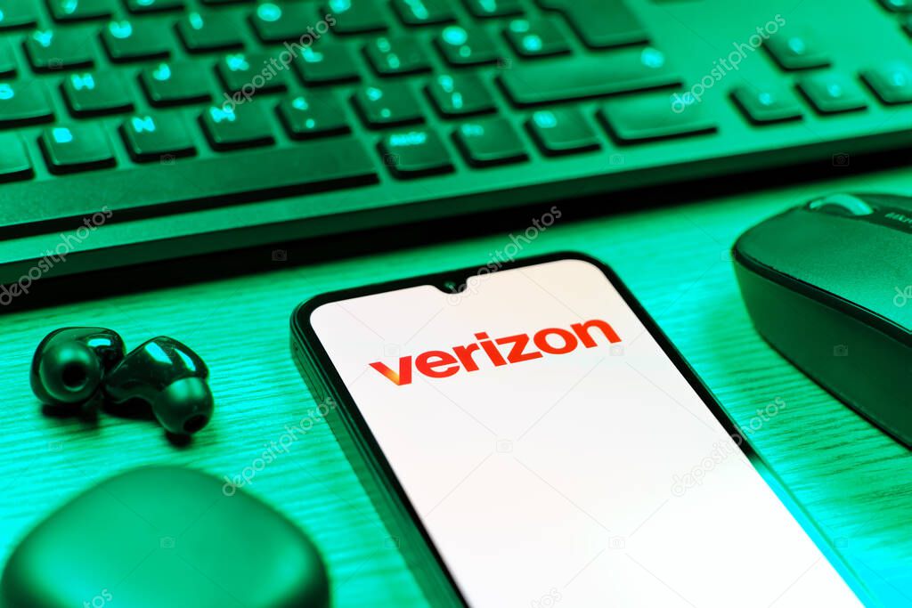 Prague, Czechia - 08 12 2025: A side view of a desk with a keyboard and a mobile phone displaying the Verizon logo. Verizon is a telecom company providing wireless and broadband services.
