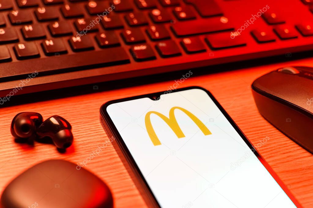 Prague, Czechia - 08 12 2025: A side view of a desk with a keyboard and a mobile phone displaying the McDonalds logo. McDonalds is a fast-food chain serving burgers, fries, and more.
