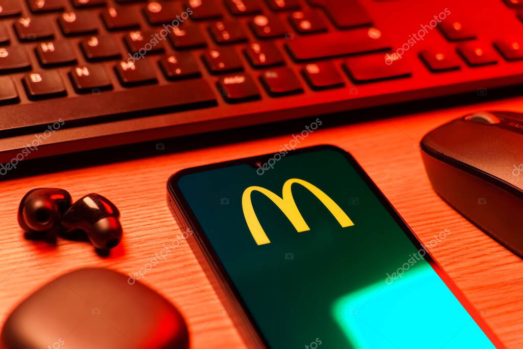Prague, Czechia - 08 12 2025: A side view of a desk with a keyboard and a mobile phone displaying the McDonalds logo. McDonalds is a fast-food chain serving burgers, fries, and more.
