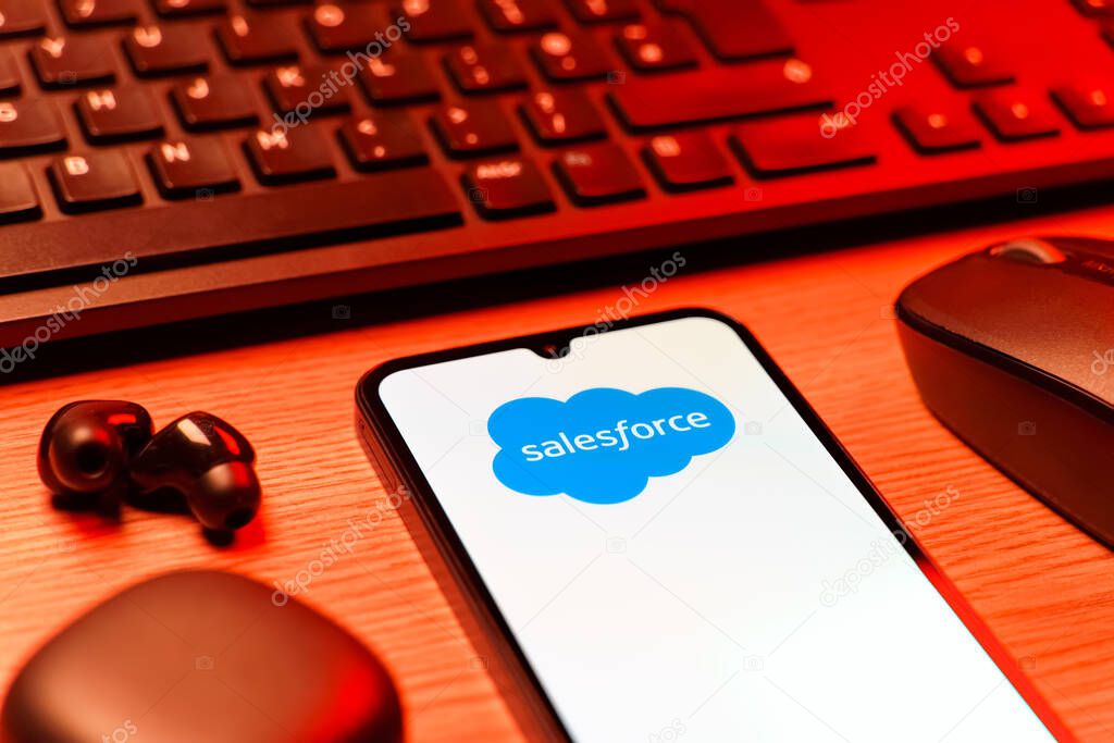 Prague, Czechia - 08 12 2025: A side view of a desk with a keyboard and a mobile phone displaying the Salesforce logo. Salesforce is a platform for customer relationship management and cloud services.