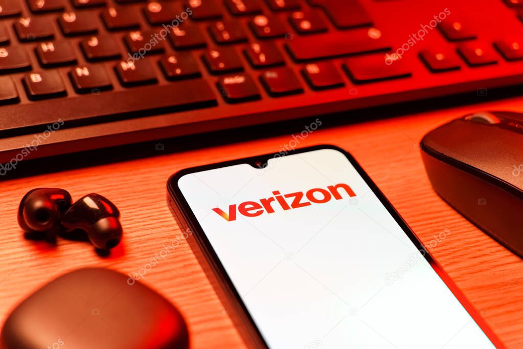 Prague, Czechia - 08 12 2025: A side view of a desk with a keyboard and a mobile phone displaying the Verizon logo. Verizon is a telecom company providing wireless and broadband services.