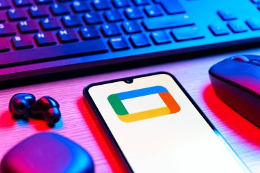 Prag, Çek Cumhuriyeti - 08 12 2025: Google TV logosunu gösteren klavyesi ve cep telefonu olan bir masanın yan görüntüsü. Google TV film, program ve uygulamalar için bir platformdur..