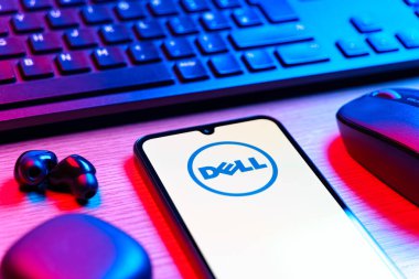 Prag, Çek Cumhuriyeti - 08 12 2025: Dell logosunu gösteren klavyesi ve cep telefonu olan bir masanın yan görüntüsü. Dell bilgisayar ve bilişim çözümleri üreten bir teknoloji şirketidir..