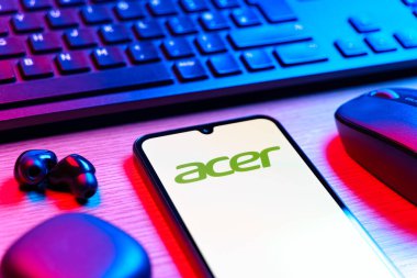 Prag, Çek Cumhuriyeti - 08 12 2025: Acer logosunu gösteren klavyesi ve cep telefonu olan bir masanın yan görüntüsü. Acer bilgisayar ve elektronik üreten bir teknoloji şirketidir..