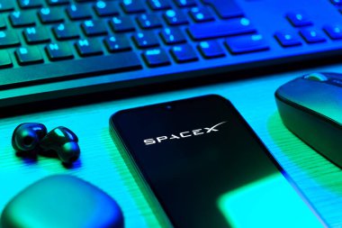 Prag, Çek Cumhuriyeti - 08 12 2025: SpaceX logosunu gösteren klavyesi ve cep telefonu olan bir masanın yan görüntüsü. SpaceX uzay keşfi ve roket fırlatmaları için özel bir şirkettir..
